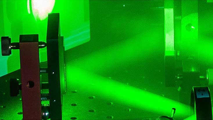 Grünes Laserlicht wird gebrochen in Strahlen
