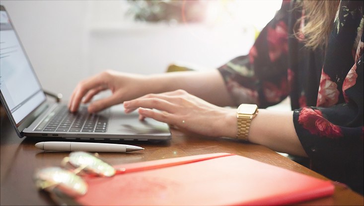 Person tippt am Laptop