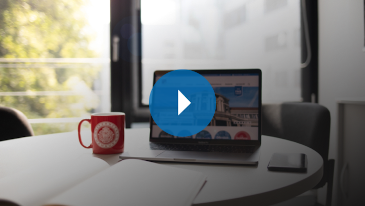 Laptop und Heft auf einem Tisch