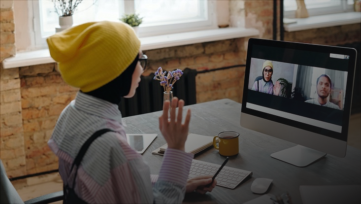 Frau gestikuliert bei Videokonferenz am Computer