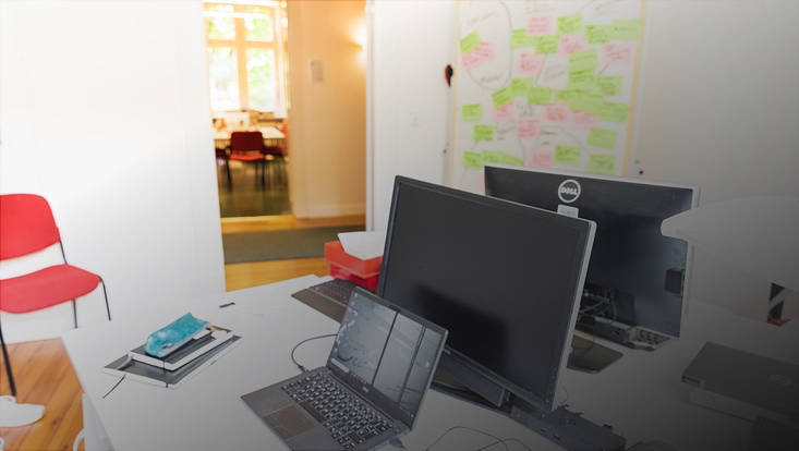 Zwei Computer und ein Laptop auf einem Tisch