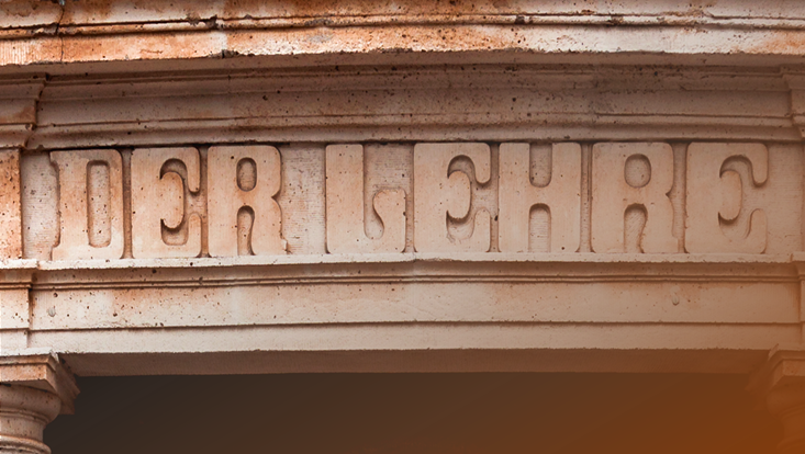 Schriftzug "Forschung, Lehre, Bildung" am Hauptgebäude der Universität Hamburg. Das Wort "Lehre" ist in den Fokus des Bildes gesetzt.