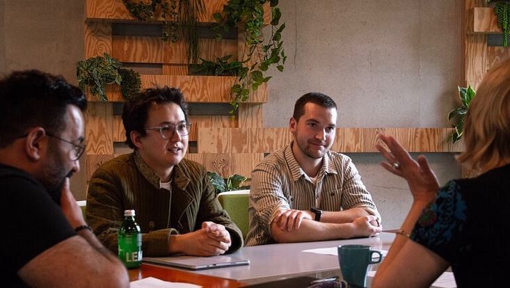 Vier Menschen sitzen unterhaltend an einem Tisch